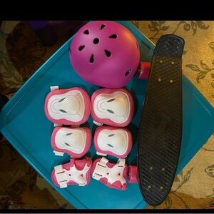 Used once. Skateboard, medium sized kids helmet and safety pad set in pink.